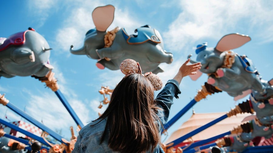 Girl Waving at Flying Dumbo [Source: Disney World]